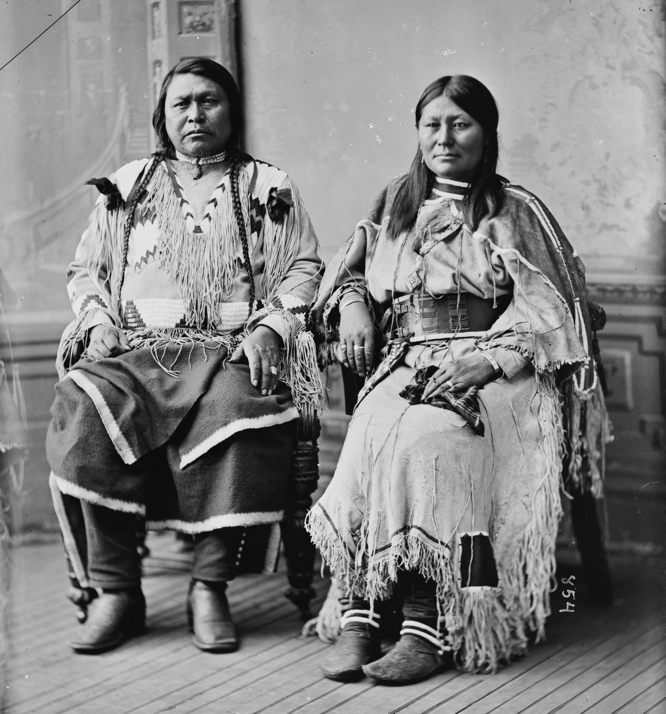 Ouray and Chipeta seated in fringed buckskin, facing the camera.